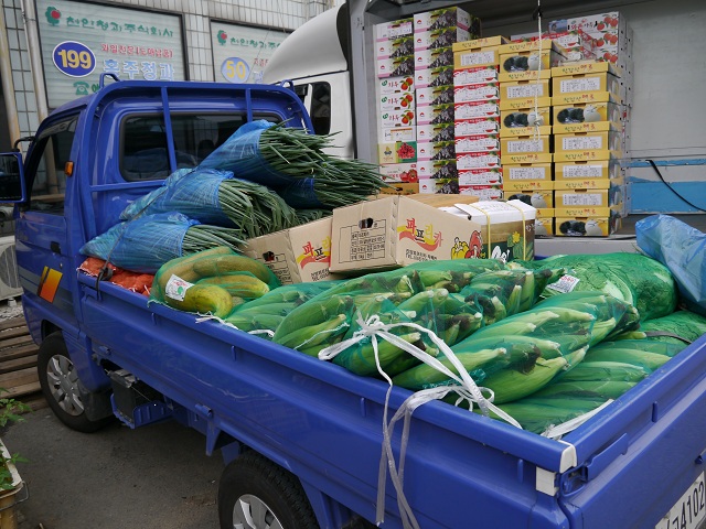 옥수수와 다른 야채 과일을 실어 놓은 소매 트럭. 돈좀 많이 버셨으면.