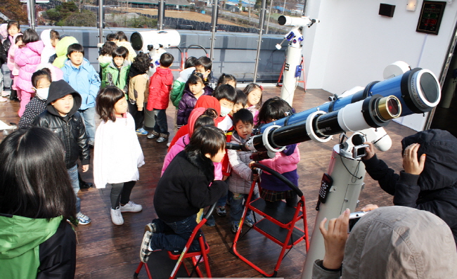 어린이들이 망원경을 이용해 천체 관측체험을 하고 있다.