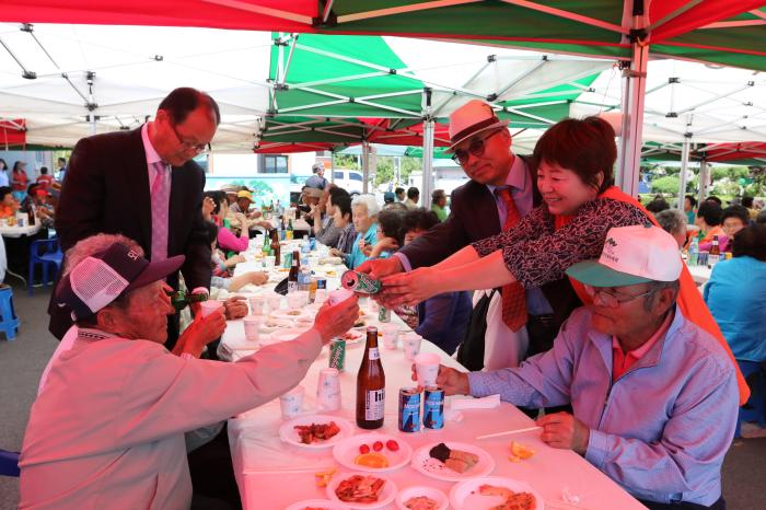 유병욱·정혜영 부부(오른쪽)와 이병복 비봉면주민자치위원장이 행사에 참석한 노인들에게 음료를 대접하고 있다. 
