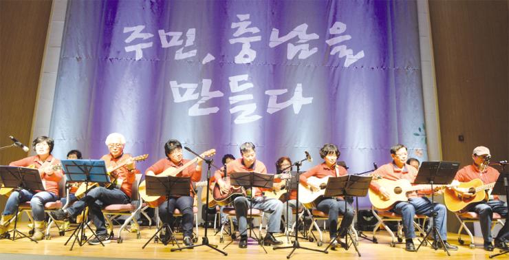 ‘제2회 동네자치한마당’ 행사에 참여한 주민들이 주민자치센터 프로그램 경연대회에서 통기타를 연주하고 있다.