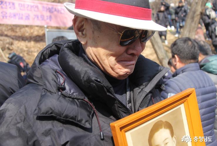 1950년 한국전쟁 당시 경찰과 치안대에 의해 부역혐의로 불법 살해된 아산지역 희생자에 대한 유해발굴이 시작됐다. 당시 아버지를 잃은 김광욱 유족회원(왼쪽)이 아버지 사진을 들고 흐느끼고 있다. 