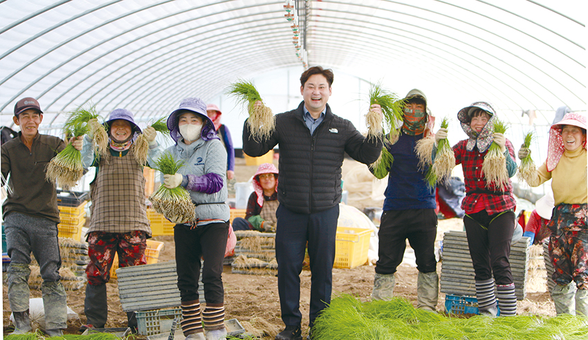 청년농부 김동완 씨(가운데)가 작업장에서 일꾼들과 함께 달래를 들어 보이고 있다.