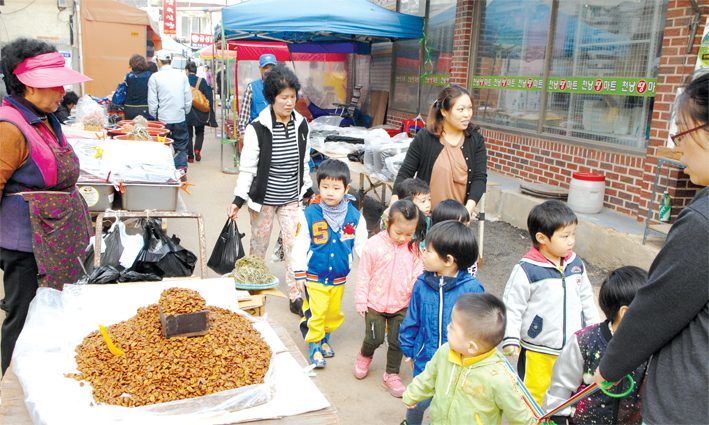 유치원 아이들이 천안 성환이화시장을 둘러보다 번데기를 신기한 듯 바라보고 있다. 100년의 전통을 간직한 이곳은 근현대사의 맥을 잇는 역사의 현장이다.