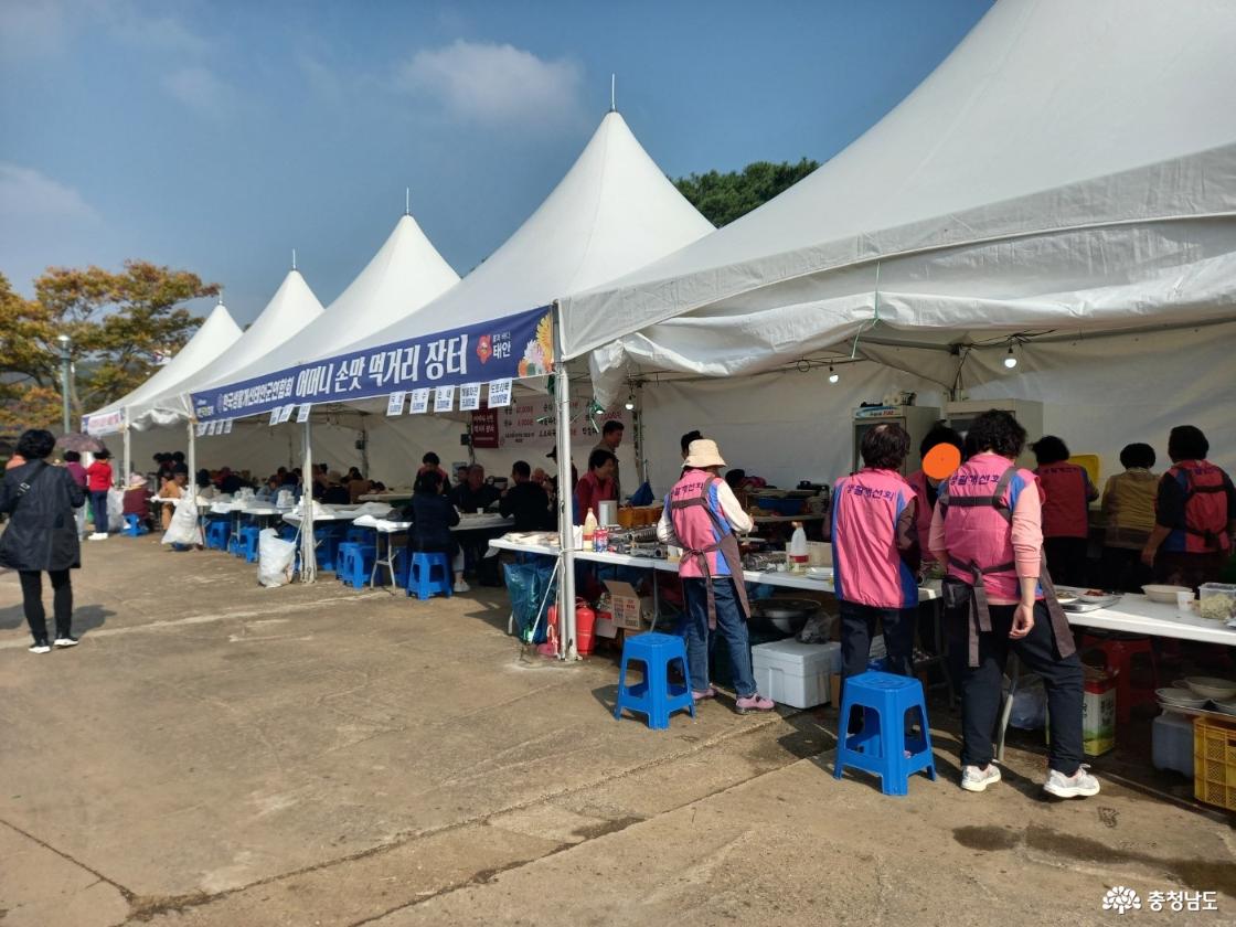 여러 천막아래 간이 테이블과 간이 의자를 놓고 다양한 먹거리를 판매하고 있다.