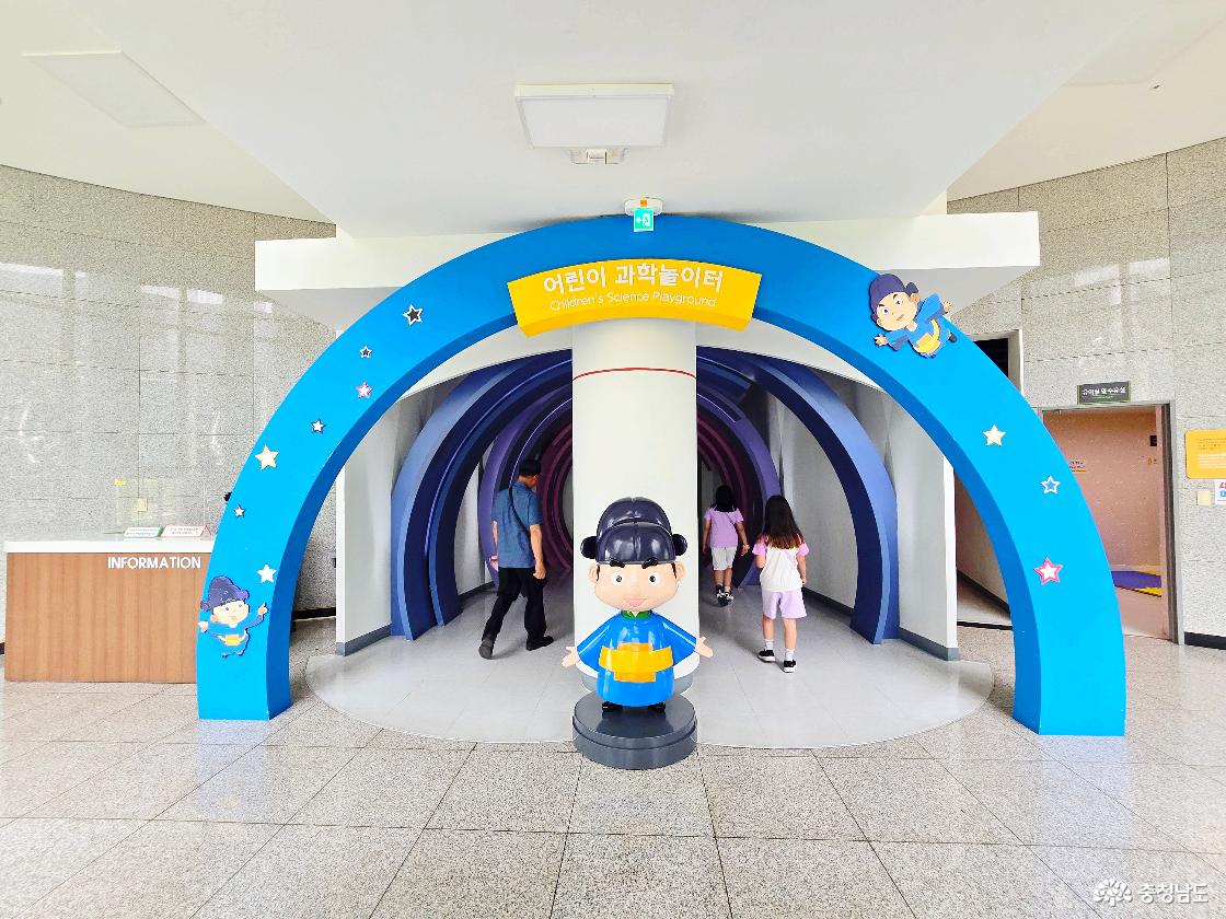 장영실과학관 어린이 과학놀이터 입구로, 파란색 아치형 구조물과 장영실 캐릭터 조형물이 있어 아이들이 흥미롭게 입장할 수 있는 공간입니다.