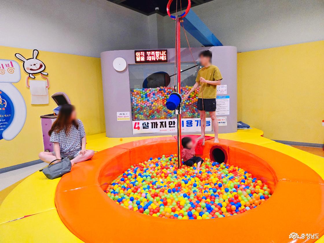 알록달록한 공이 가득한 볼풀장과 매달린 체험 장치가 있는 장영실과학관 어린이 놀이 공간으로, 어린아이들이 즐겁게 놀 수 있는 실내 시설입니다.