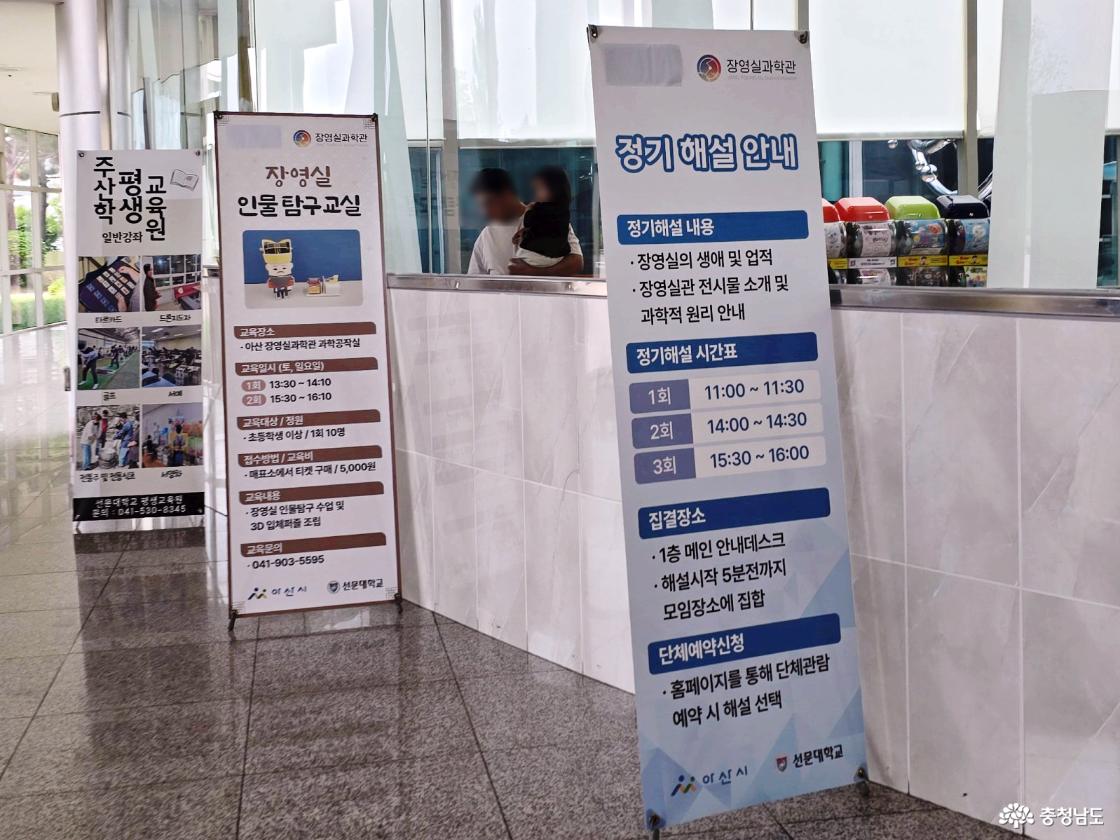 장영실과학관 1층 안내데스크 앞에 세워진 정기 해설 안내 배너와 장영실 인물 탐구교실 안내 배너 모습입니다.