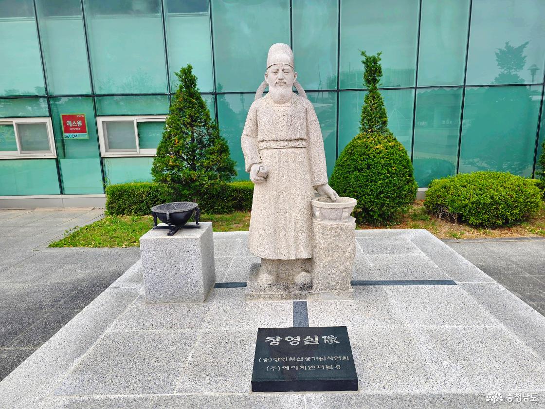 장영실과학관 외부에 세워진 장영실 동상 모습으로, 조선시대 과학자 장영실의 업적을 기리는 조형물이 건물 앞에 전시되어 있습니다.