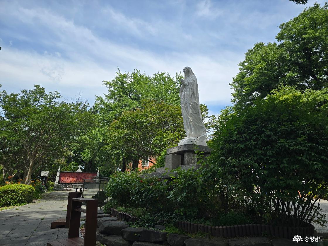 공세리성당 경내 성모마리아상과 울창한 나무가 어우러진 산책 명소 풍경