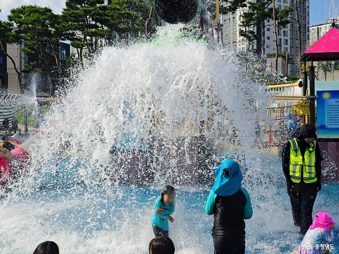 금산 아인수림공원 물놀이장의 대형 물바구니에서 쏟아지는 물줄기를 맞으며 노는 아이들