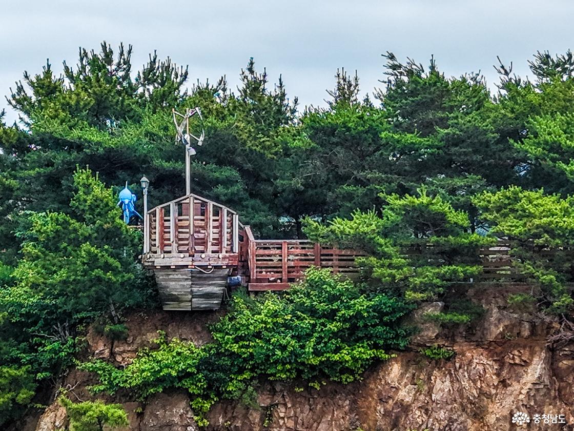 붉은 절벽 위 해송림 사이에 속동전망대 배 모양 포토존