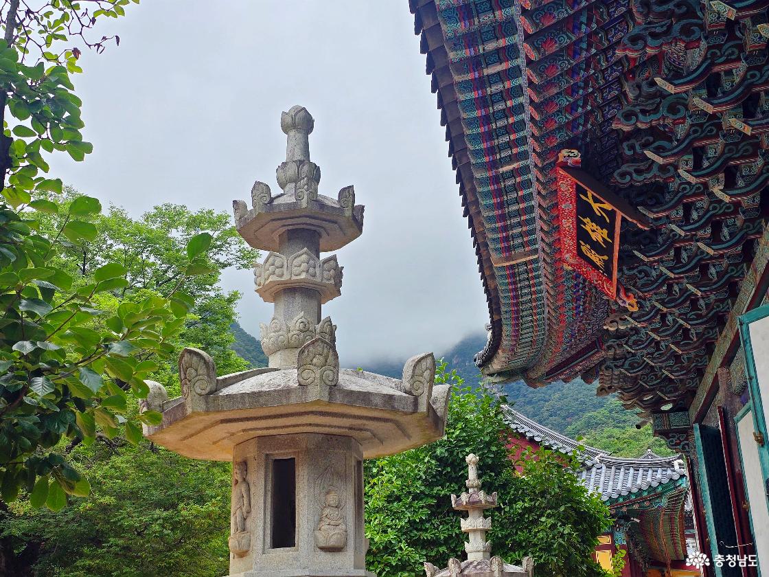 동학사 대웅전의 화려한 단청과 석등, 뒤로 보이는 계룡산 풍경