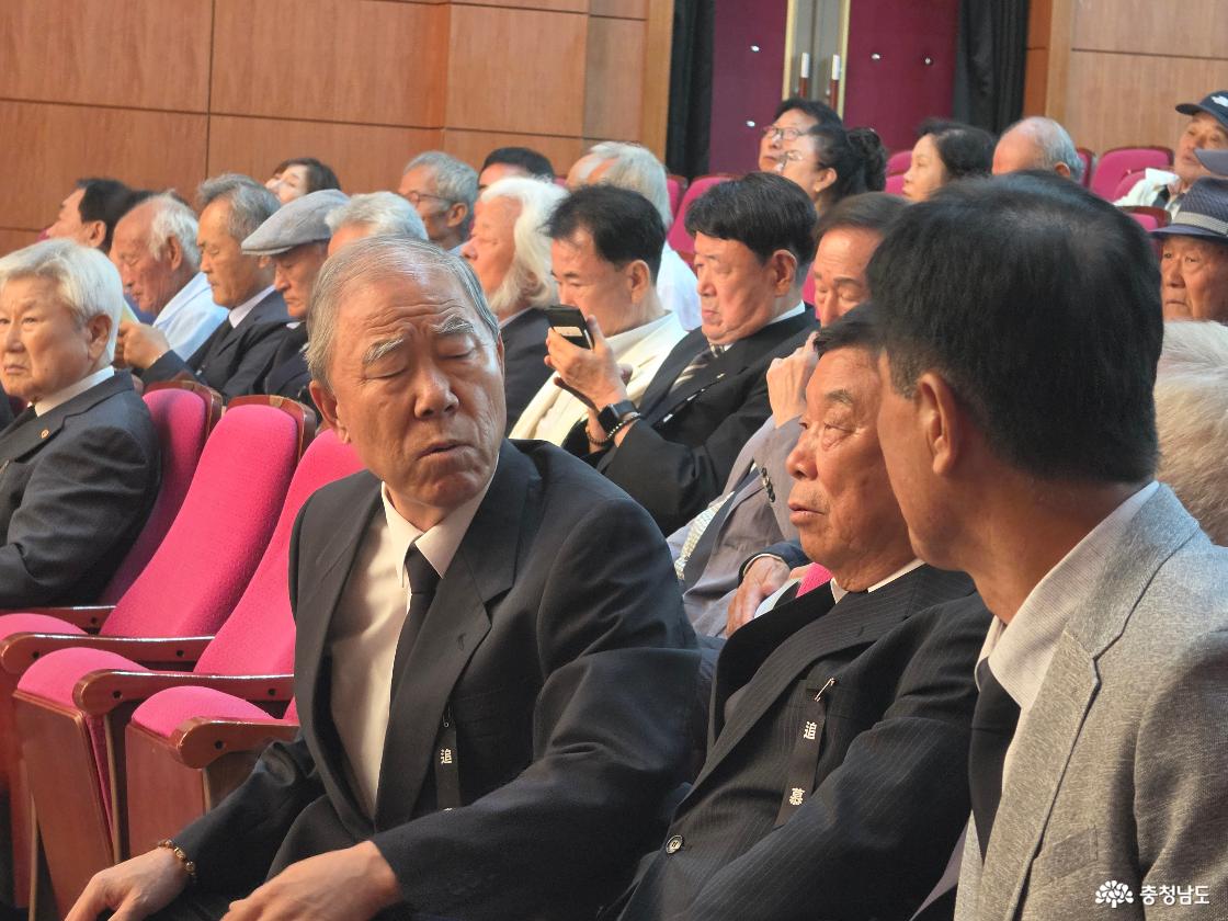 추모행사에 참석한 유족들이 객석에서 이야기를 나누며 행사를 함께하고 있는 모습입니다.